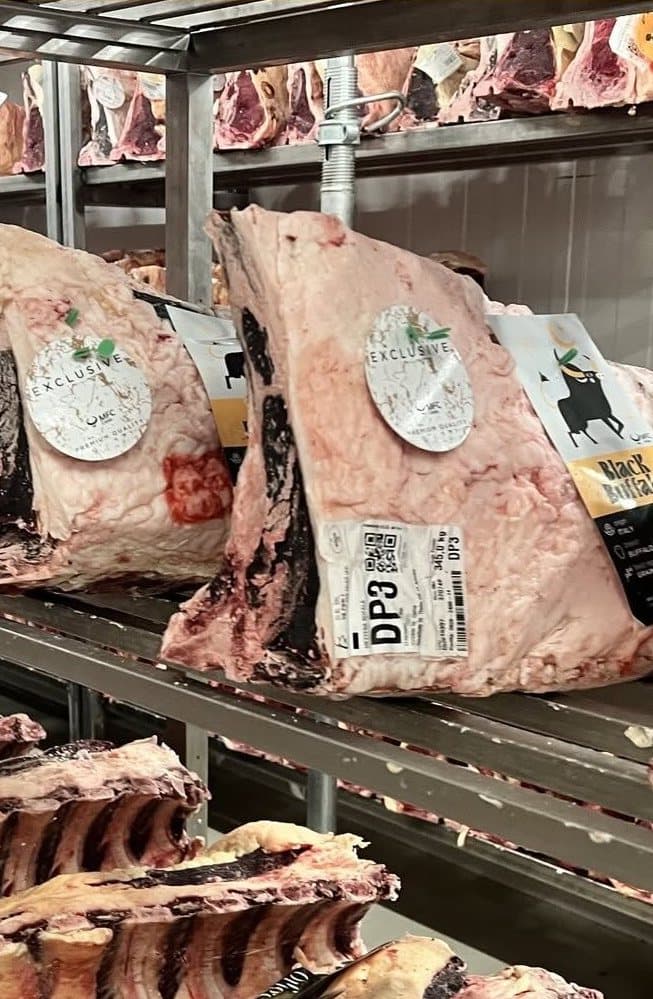 Des carrés de bœuf en maturation sur les étagères inox d'une chambre froide
