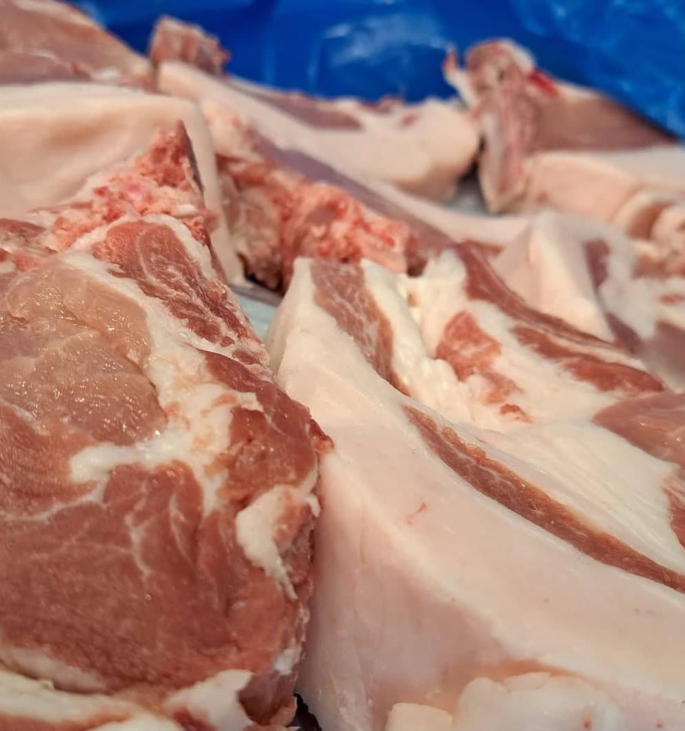 Des pièces de porc fraîchement découpées, la couenne et le gras bien blancs